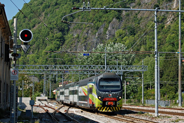 [La motrice EB 711-050 del convoglio TSR R3 054 di Trenord entra nella
stazione di Laveno Mombello FS proveniente da Luino.  Sulla sinistra
si vede il binario di raccordo con la rete di FerrovieNord (Laveno, 22
aprile 2017)]