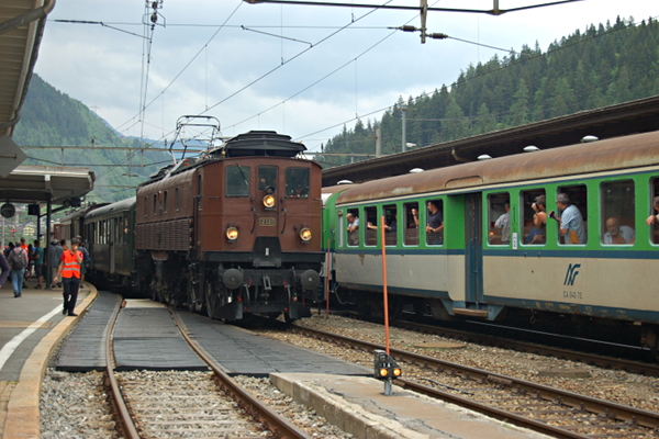 [Locomotiva storica Be 4/6 12320 di SBB Historic nella stazione di
Airolo sulla ferrovia di valico del San Gottardo, pronta a partire
verso Göschenen con tre carrozze d'epoca.  In secondo piano le
carrozze Leichtstahlwagen delle Ferrovie Nord Milano impegnate nel
treno storico "Gottardo Express" Airolo, 3 giugno 2017.]